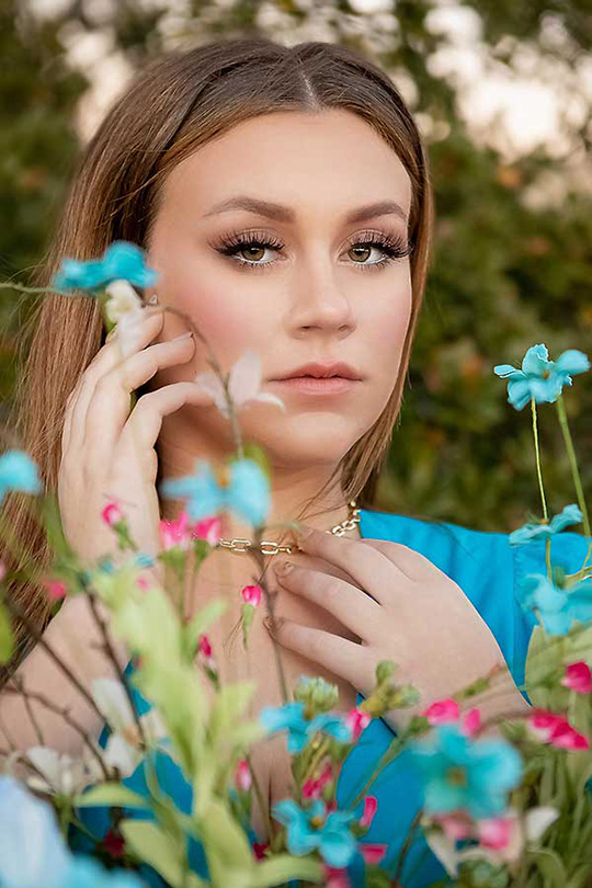 Houston Senior Photographer: Beautiful Magazine Style Senior Portraits By Atascocita Photography 4 Houston Senior Photographer photographs a High school senior girl poses behind colorful wildflowers during outdoor portrait session